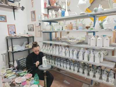 Da questo ambiente accediamo al capannone industriale vero e proprio, in cui ogni angolo � destinato a uno specifico passaggio della lavorazione. In particolare la decorazione, che qui usufruisce di una silenziosa stanzetta apposita. Proprio in questo piccolo locale troviamo infatti una giovane alle prese con un�oliera: con i sapienti tocchi del suo pennello la sta arricchendo con motivi vegetali